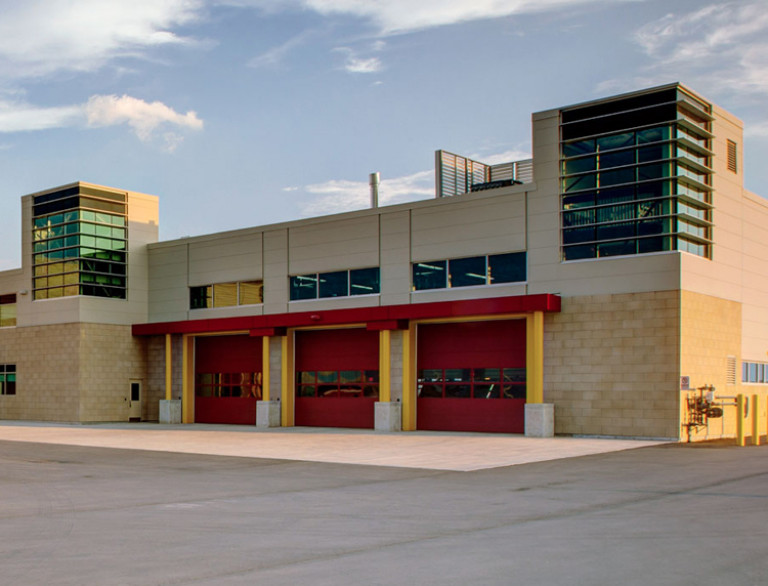 The facade of the Garry W. Morden Centre with focus on the three red garage doors.
