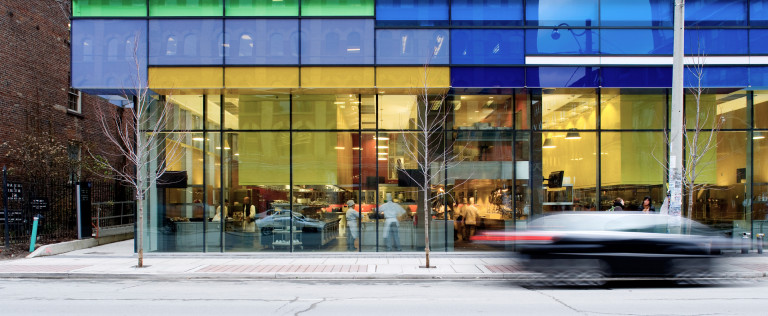 A panorama shot at street level of the glass facade of George Brown School of Hospitality and Tourism.