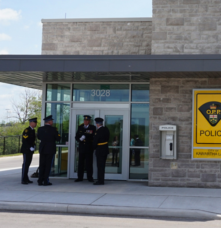 A group of policemen at the entrance of the Kawartha OPP.
