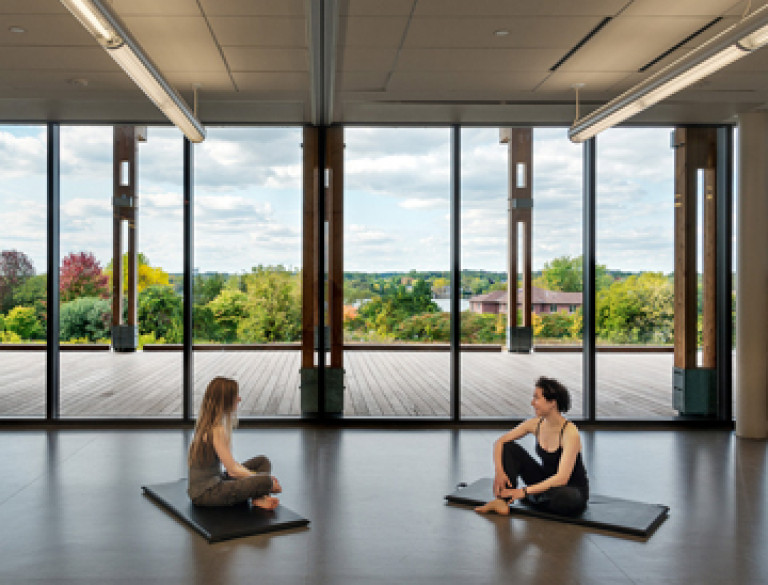 The exercising studio of the Oak Ridges Community Centre with two people practicing yoga.