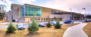 A panorama shot of the facade of the St. Thomas Aquinas Secondary School including the parking lot.