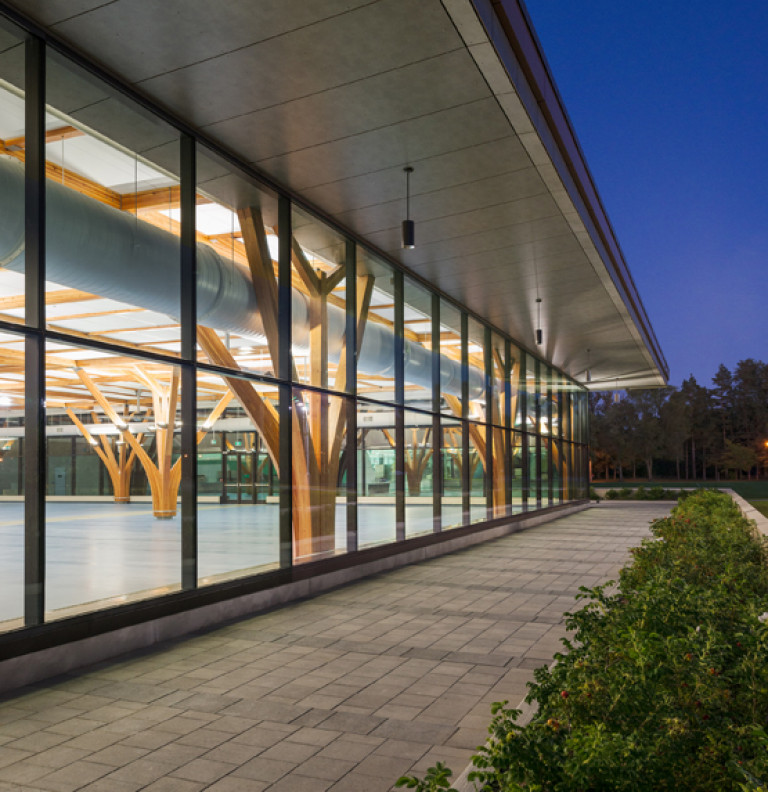 An exterior shot showing the lighted glass facade of the Vickers Dining Facility.