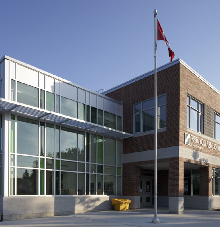 The exterior of the Bradford FC Cooke Public School with Canada flag in the foreground.