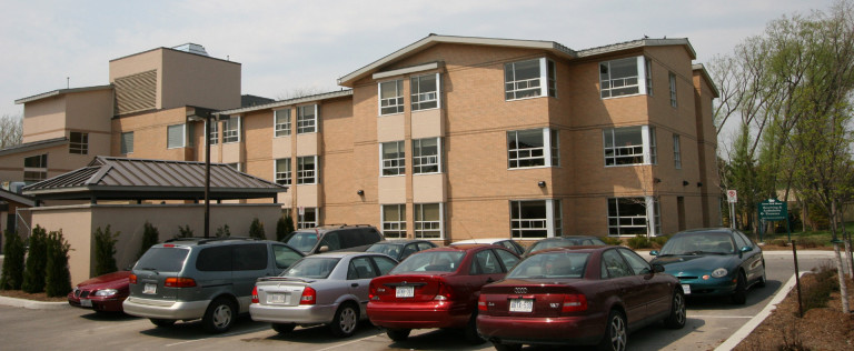 External view of the Grove Park Long Term Care Facility and its parking space.